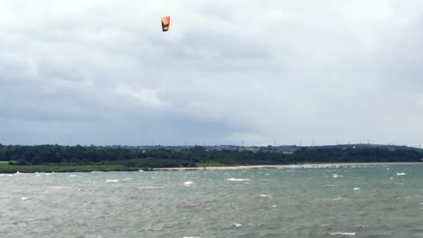 un kitesurf saltando 20 pies en el aire y aterrizando con estilo, en un ventoso día de verano | playa de portobello, edimburgo | filmado en hd a 24 fps cinemáticos