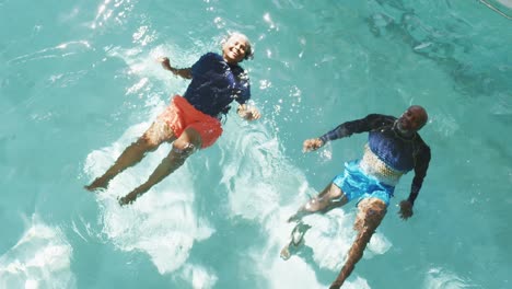 video of happy senior american african couple exercising in the pool