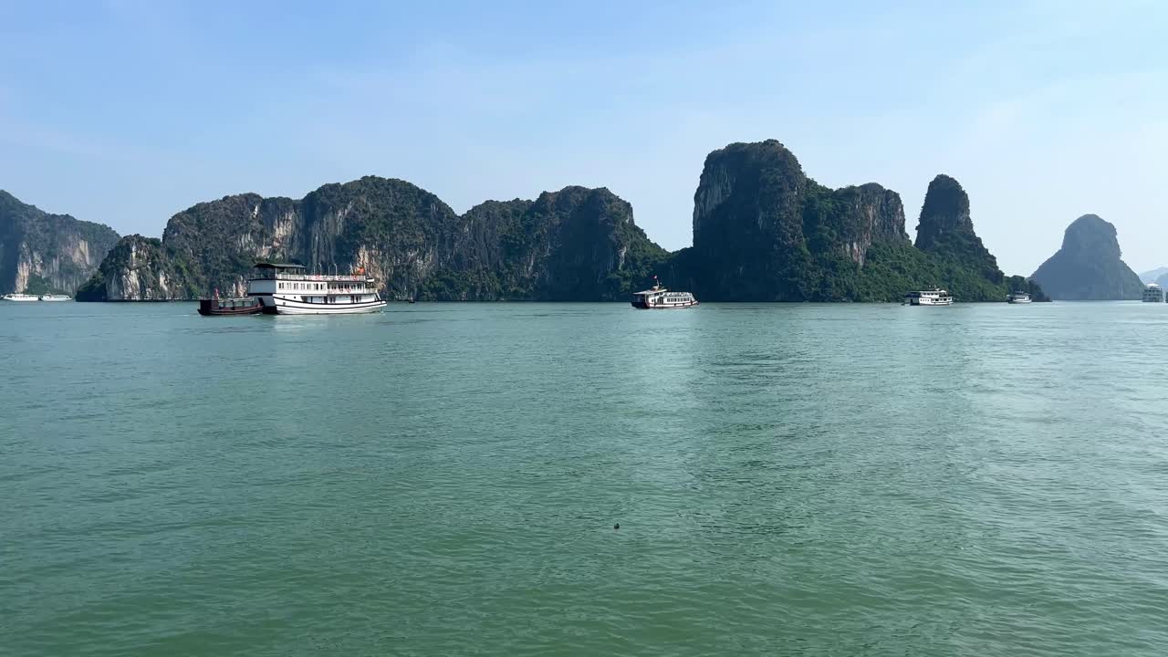 día soleado en la bahía de halong con botes chatarra que rodean formaciones rocosas