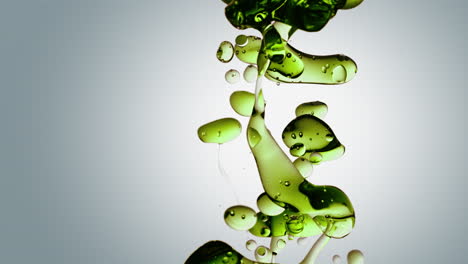 burbujas de aceite verde transparente y formas fluidas en agua purificada sobre un fondo degradado blanco