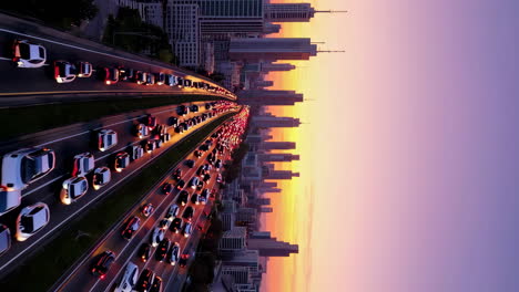 aerial view of heavy traffic on a highway at dusk with a city skyline