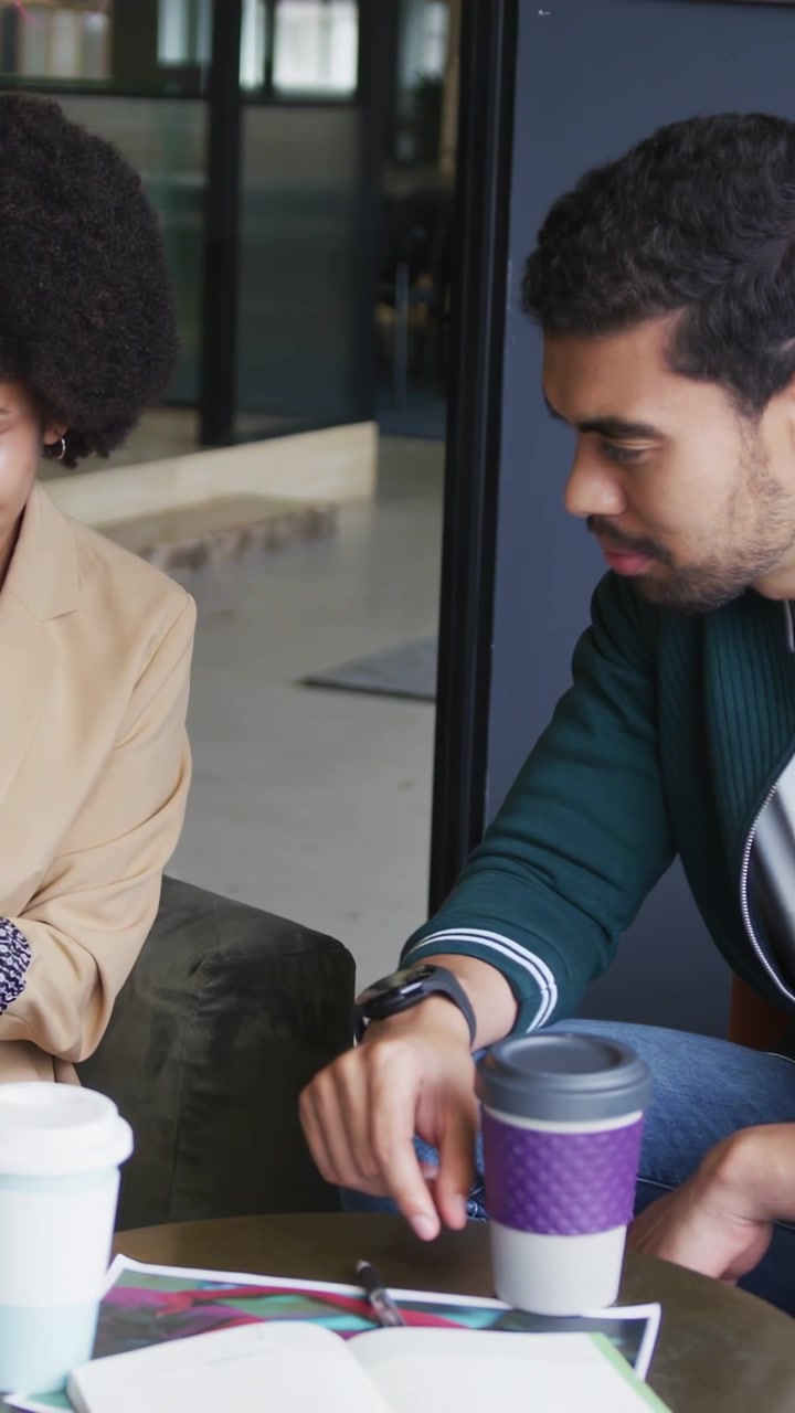 Video verticale: Uomo che picchietta una tazza viola mentre una donna legge, generando badge animati per il marketing.