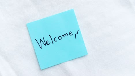 zoom into a warm welcome a blue note a white surface indoor setting close-up perspective