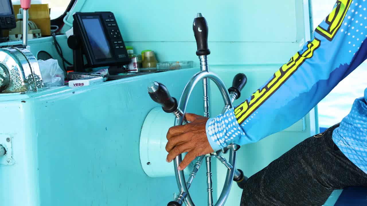 태국 푸켓에서 요트를 능숙하게 조종하는 사람이 활기찬 해양 환경에서 정확한 통제와 항해를 보여줍니다.