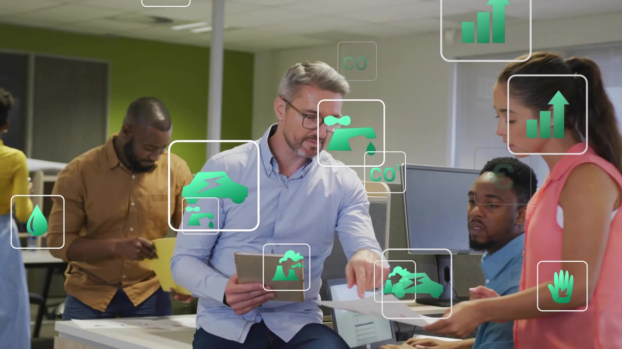 Lead with tablet, pointing, coworker handing pages, green icons overlaying data in office review
