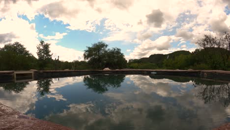 tiro de lapso de tiempo de gota de lluvia cayendo sobre la superficie del lago y cambio de clima a la luz del sol en el desierto