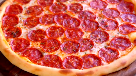 salami-pizza auf einem holzbrett auf dem tisch. nahaufnahme.