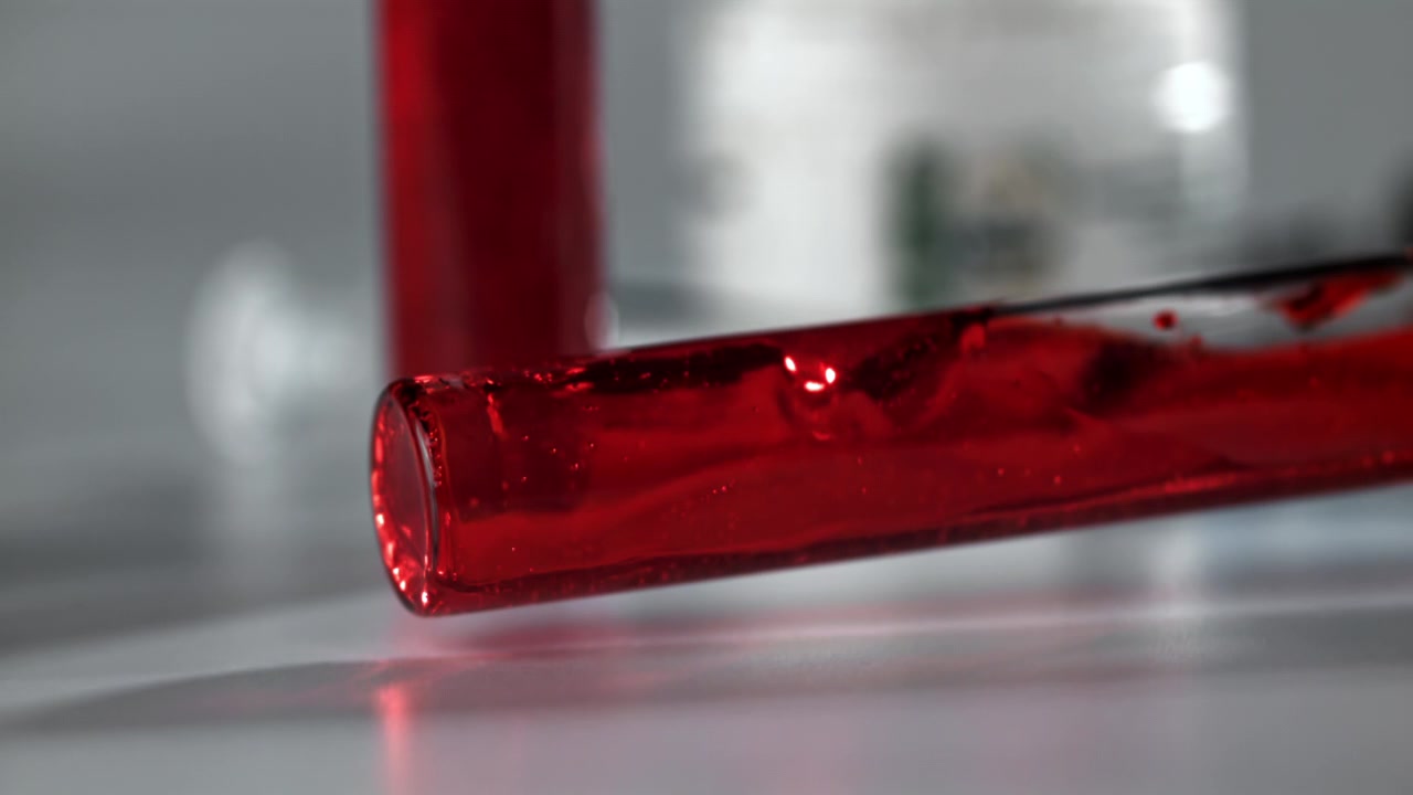 Liquido rosso che vortica in una provetta in laboratorio