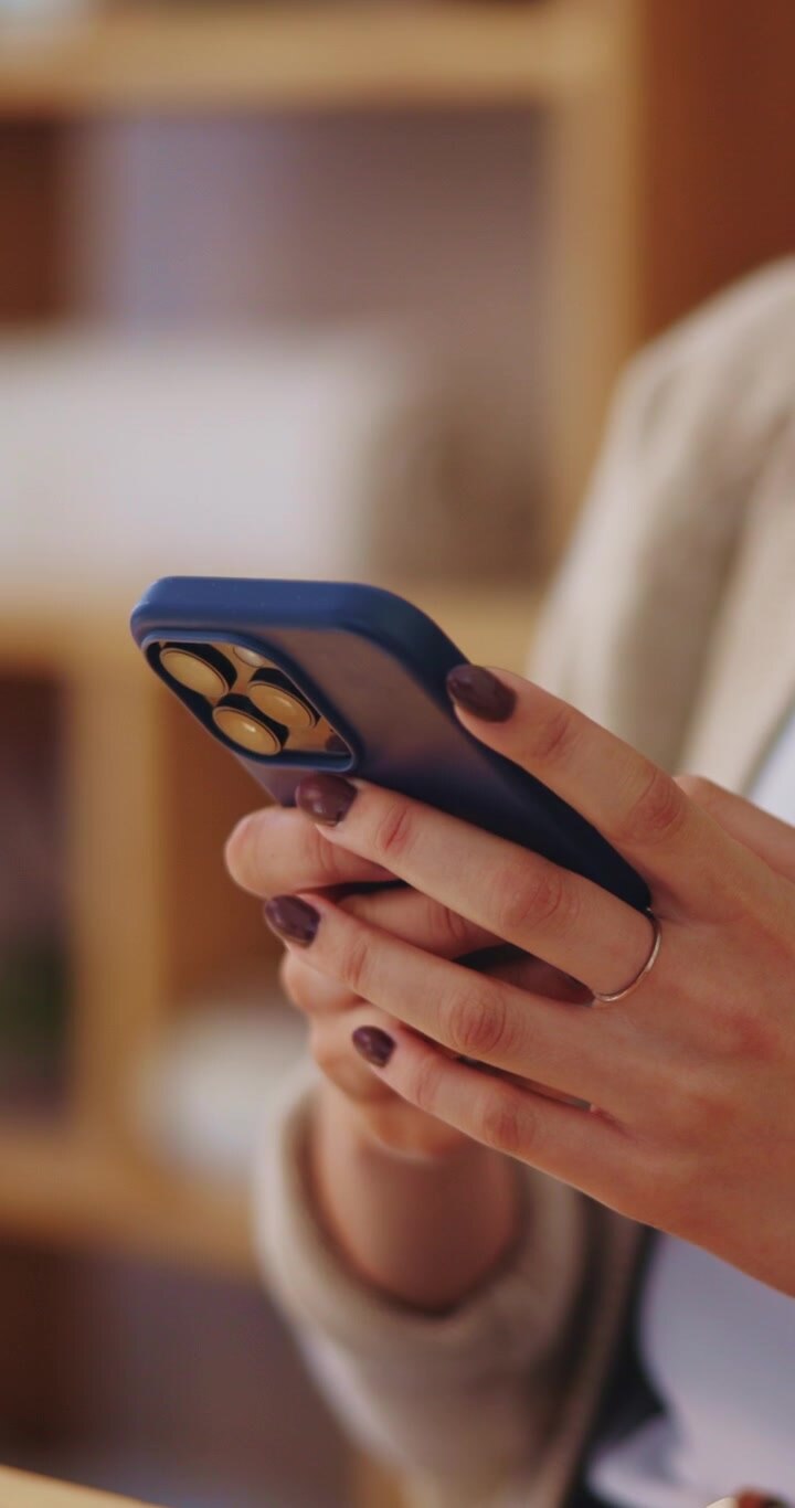 Primo piano di una donna che usa lo smartphone in un ambiente interno