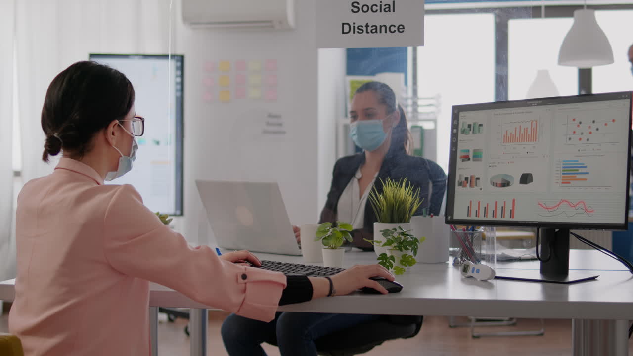 회사 팀은 컴퓨터에서 일하는 동안 금융 그래픽을보고 있습니다.