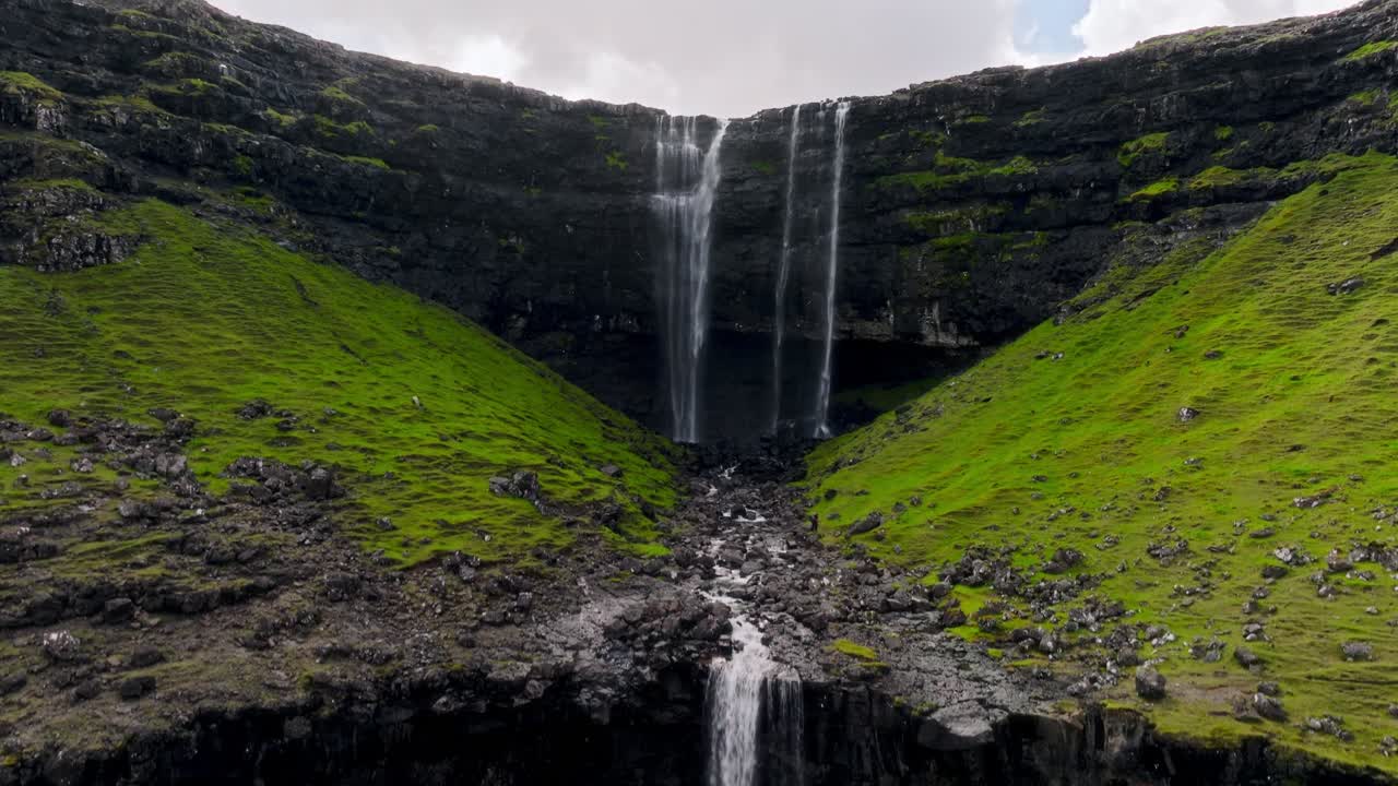 una hermosa cascada de las islas feroe cae por exuberantes acantilados verdes, serena y remota.