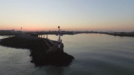 aerial: the smaller port of vlissingen, with cargo ships passing by, during sunset