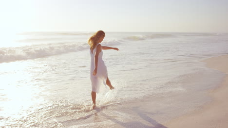 Hermosa-Mujer-Con-Vestido-Blanco-Caminando-Por-La-Playa-Al-Atardecer-En-Cámara-Lenta-Dragón-Rojo