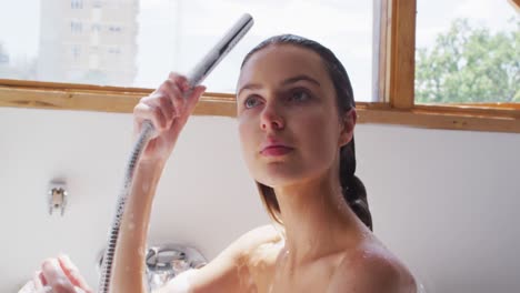 woman showering in bathtub in bathroom