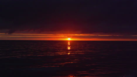 Wunderschöne-Bilder-Des-Ozeans-Bei-Nacht-Mit-Einem-Orangefarbenen-Horizont-Und-Der-Untergehenden-Sonne-Direkt-über-Dem-Wasser