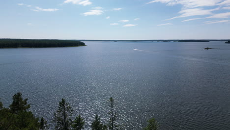 drone flyover baltic sea follow motor boat in the distance between fniland islands