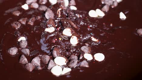 cuchara agitando chocolate derretido con salpicaduras y papas fritas de chocolate