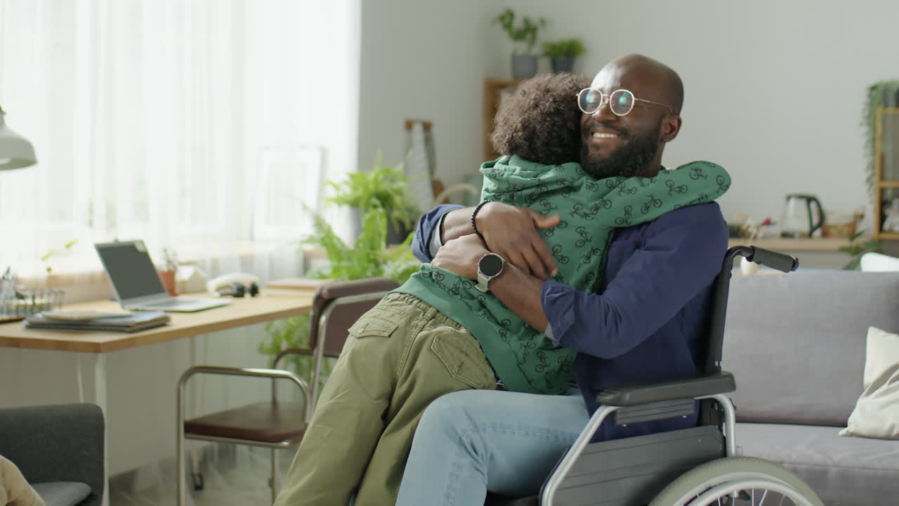 Little Boy Hugging Dad in Wheelchair at Home