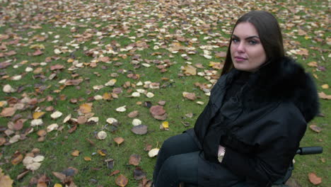 Slow-motion-shot-showing-handicapped-female-person-with-brown-hair-sitting-in-wheelchair-outdoor-in-nature