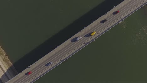 Die-Drohne-Schoss-Direkt-über-Eine-Fahrzeugbrücke,-Während-Autos-Unter-Ihr-Hindurchrasten