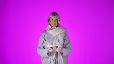 Caucasian-woman-with-scarf-takes-off-fluffy-white-ear-warmers,-studio-shot