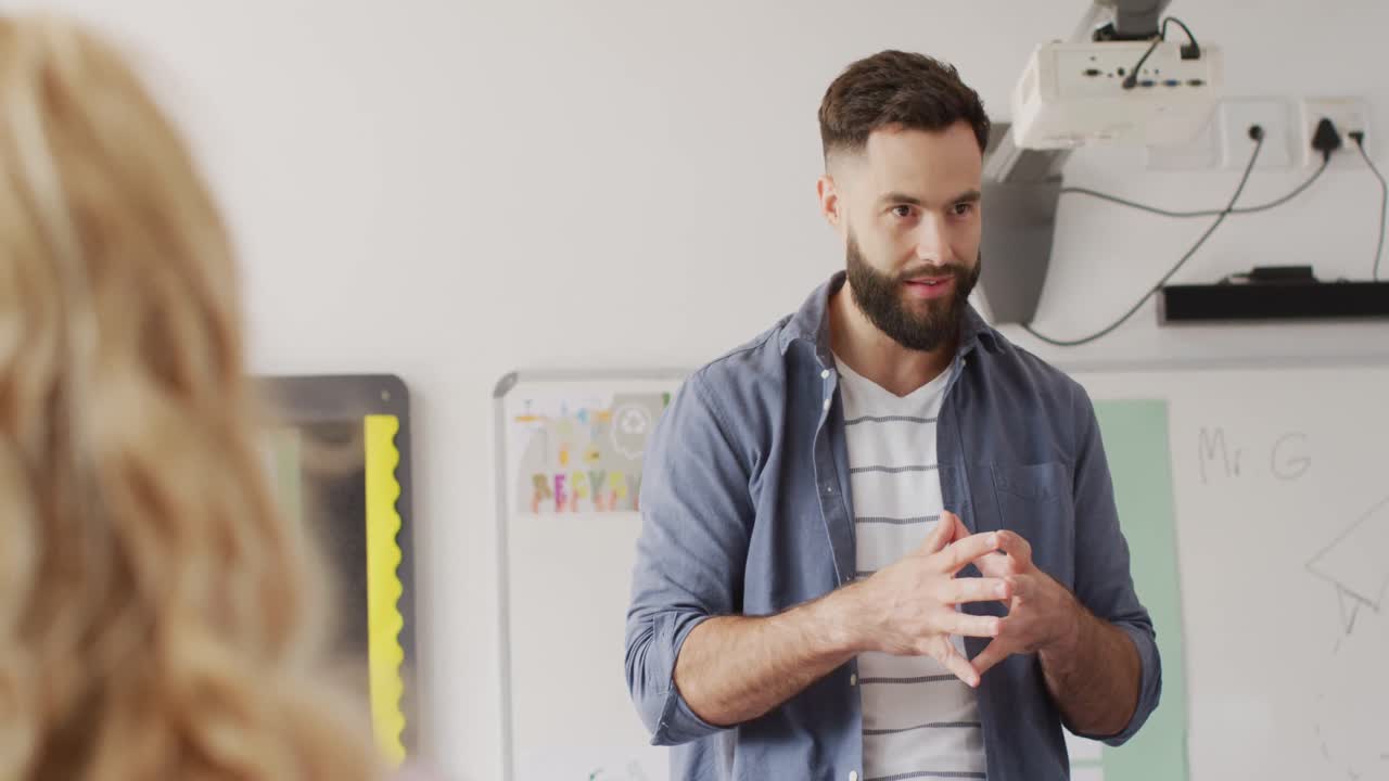 diversos maestros varones y escolares en los escritorios en el aula de la escuela