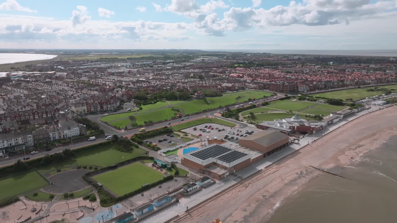 Fleetwood Central Promenade Leisure Complex And Marine Hall Theatre. Slow Pan Showing Wider Urban Area Of The Town And Its Beach. Lancashire, UK