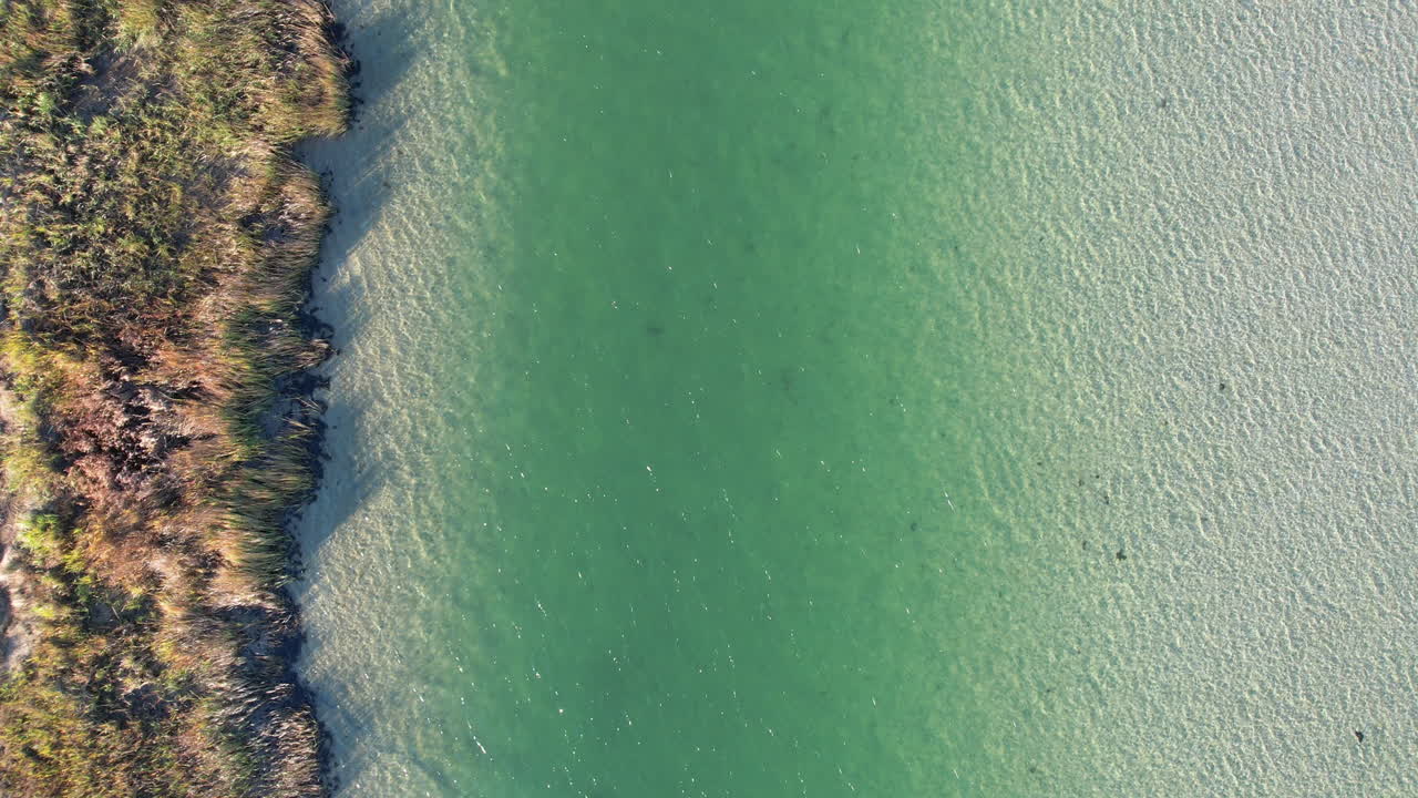 drone shot of blue ocean waters in tidal flats area, aerial footage (дронный снимок голубых океанских вод в районе приливных равнин, воздушные кадры)