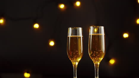 champagne glasses on dark background with lights