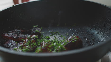 cooking bacon in a pan with herbs