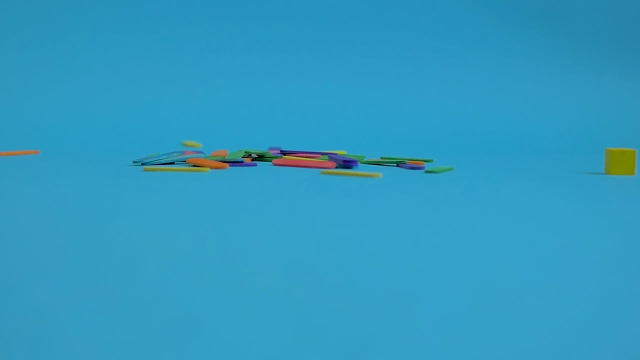 palitos de helado de colores cayendo sobre fondo de papel azul