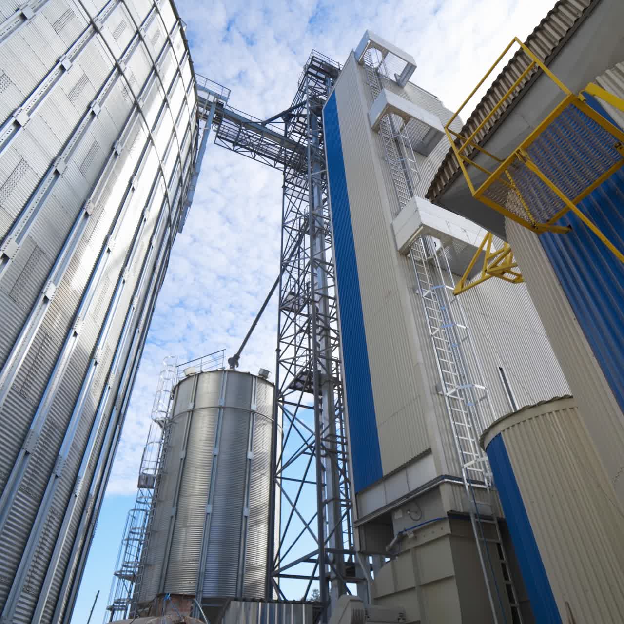 Exterior of a modern factory. Large granary for processing and drying agricultural products. Grain elevator outdoors. Close-up