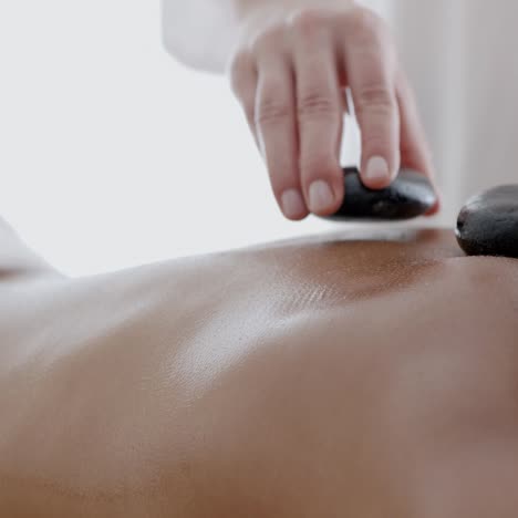 mujer recibiendo un masaje con piedras calientes