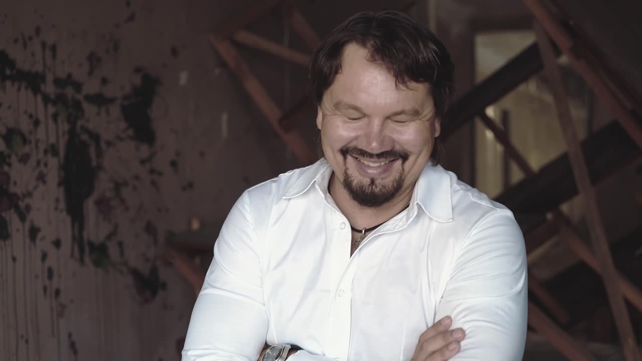 retrato de un joven brutal con una barba que se ríe de cerca