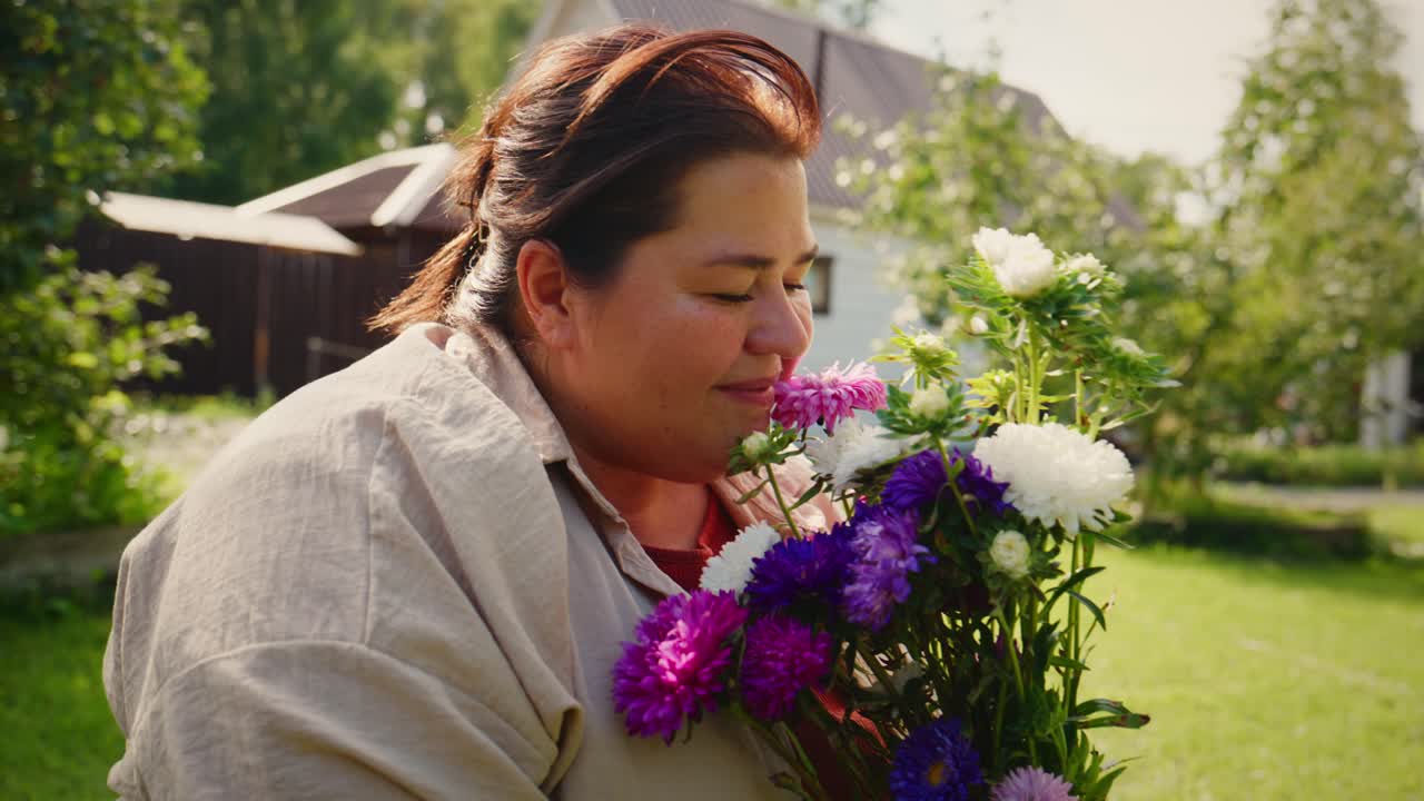 Un momento di gioia nella natura: una donna sorridente mentre sistema fiori colorati nel suo giardino, circondata da una vegetazione lussureggiante e un’accogliente casa sullo sfondo