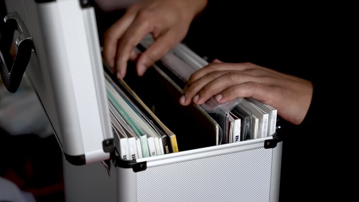 Hand Sorting Through Vinyl Records in Silver Case Music Collector Organizing Albums in Box for Personal Collection and Enjoyment