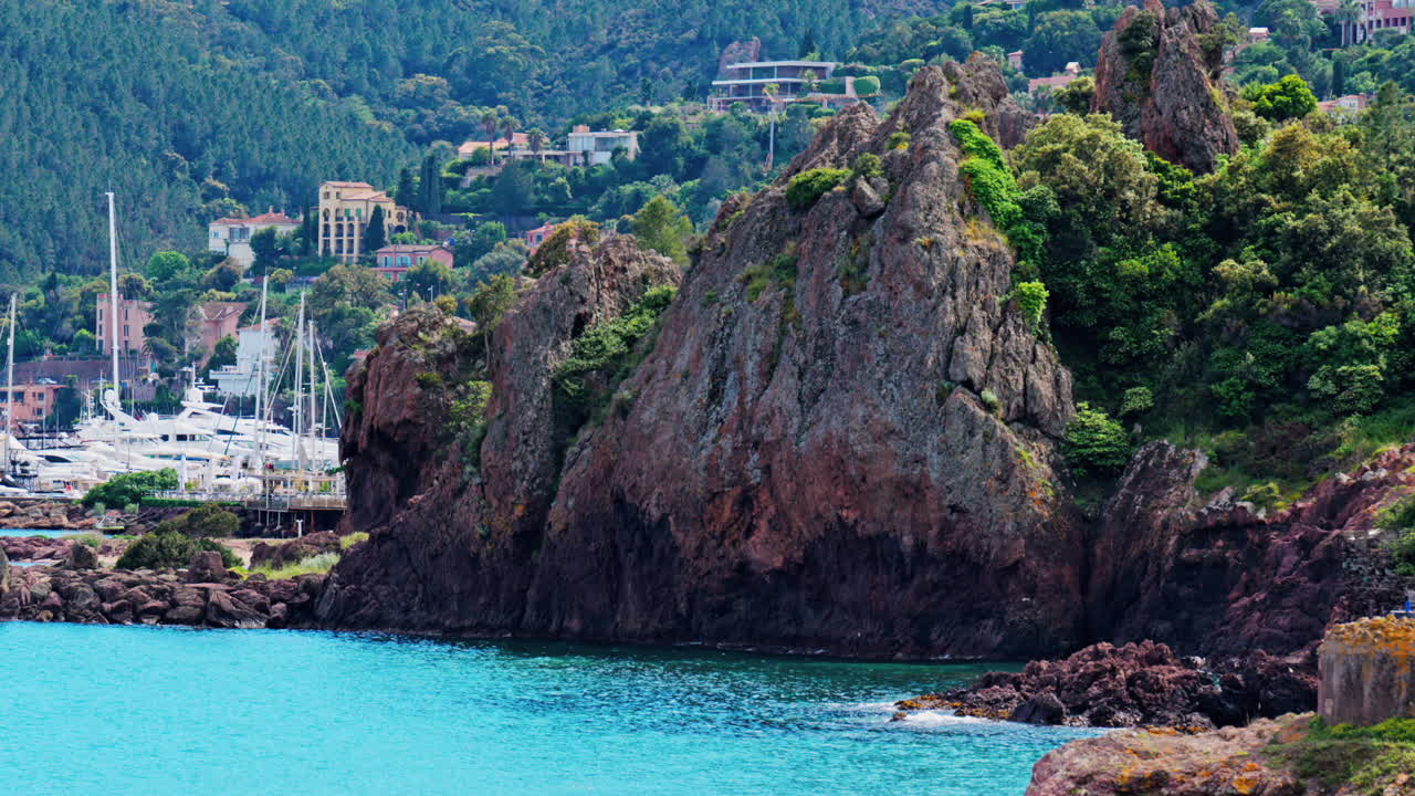Distant view of the Mandelieu-La Napoule Port in France with villas surrounded by greenery on the background