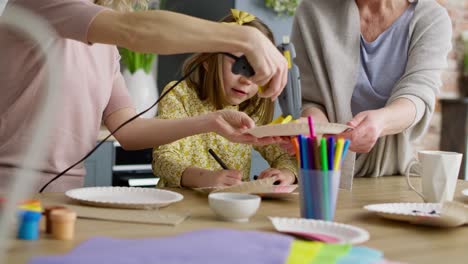 video of three generations of women making easter decorations together