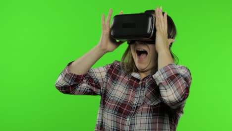 girl using vr app helmet to play simulation scary game. woman watching virtual reality 3d video