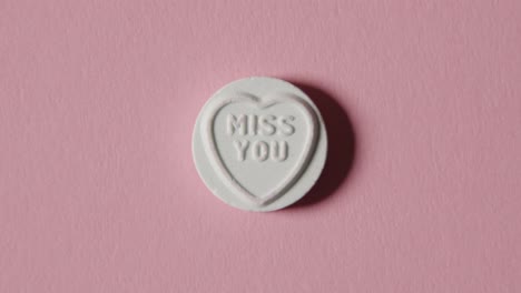 heart candy with miss you message on pink background