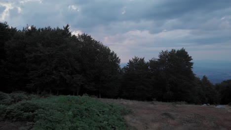 Drone-video-over-trees-at-duck-revealing-beautiful-cloudy-sunset-mountain