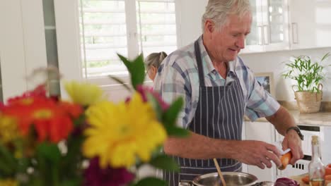 Feliz-Y-Diversa-Pareja-De-Ancianos-Usando-Delantales-Y-Cocinando-En-La-Cocina