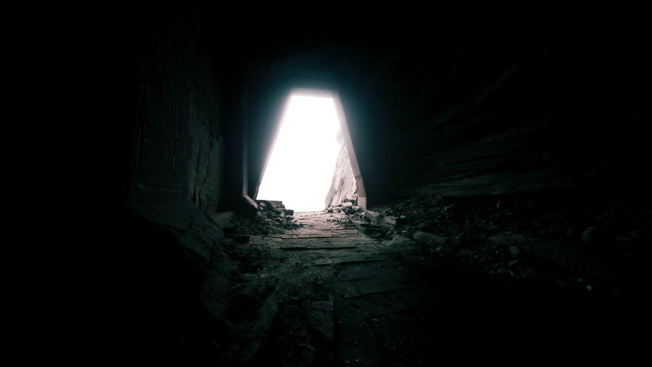 la luz emerge de un túnel oscuro en una estructura abandonada al atardecer.