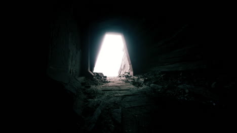 light emerges from dark tunnel in abandoned structure at sunset