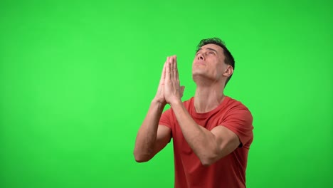 man praying distraught. with a red shirt.