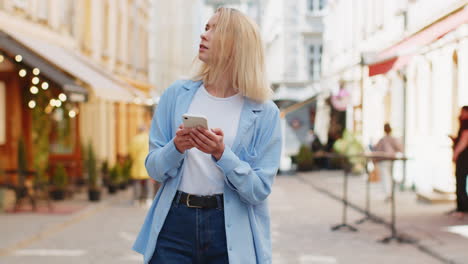 Tourist-traveler-young-woman-using-smartphone-typing-text-messages-looking-for-search-a-way-on-map