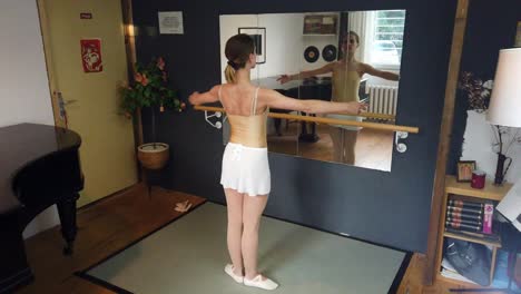 ballerina beginner practices basic steps, corrects herself in mirror