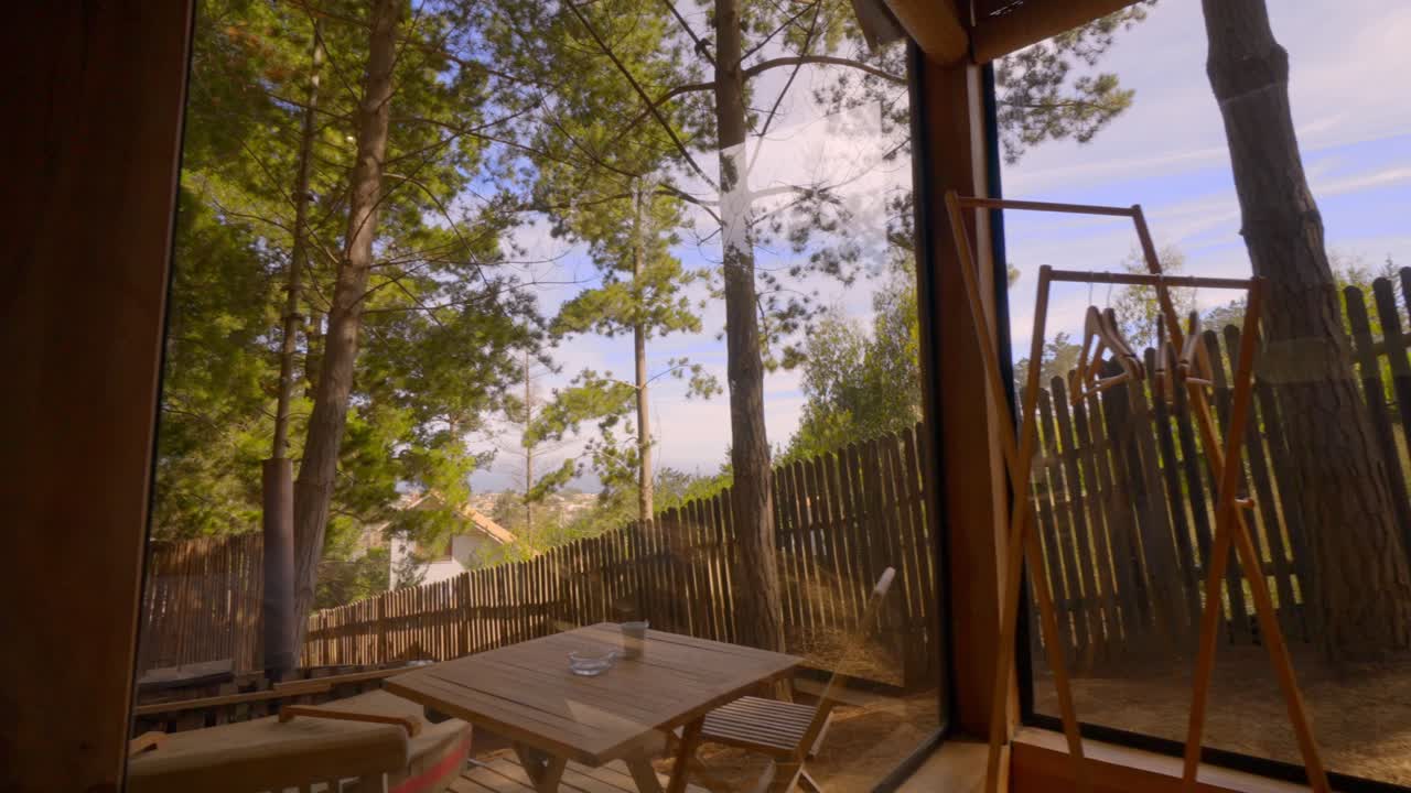 cabaña rústica de madera con vistas al bosque de pinos con la cálida luz de una puesta de sol