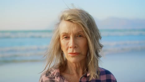 front view of active senior caucasian woman standing on the beach 4k