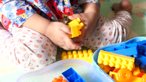 toddler playing with colorful plastic blocks